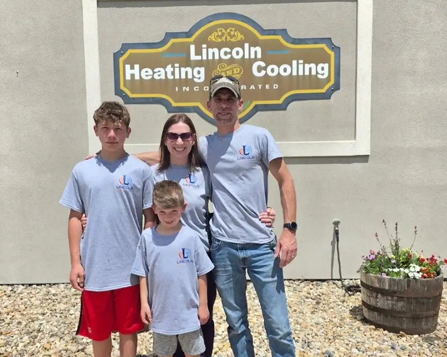 Tommy Gleason and family posing together in matching shirts outside their newly acquired Lincoln Heating & Air business in Springfield, IL