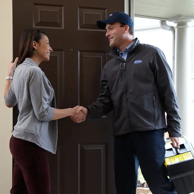 Lincoln Heating & Air technician greeting a homeowner at the front door for a scheduled Carrier air conditioning service call in Springfield, IL