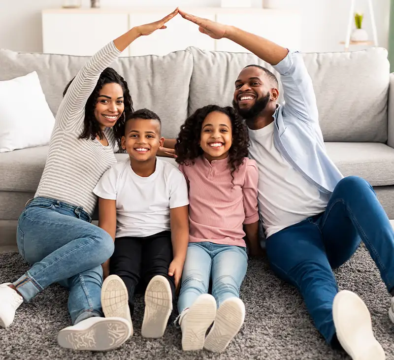 Family of four forming a protective roof shape with their hands, symbolizing home comfort from Lincoln Heating & Air in Springfield, IL